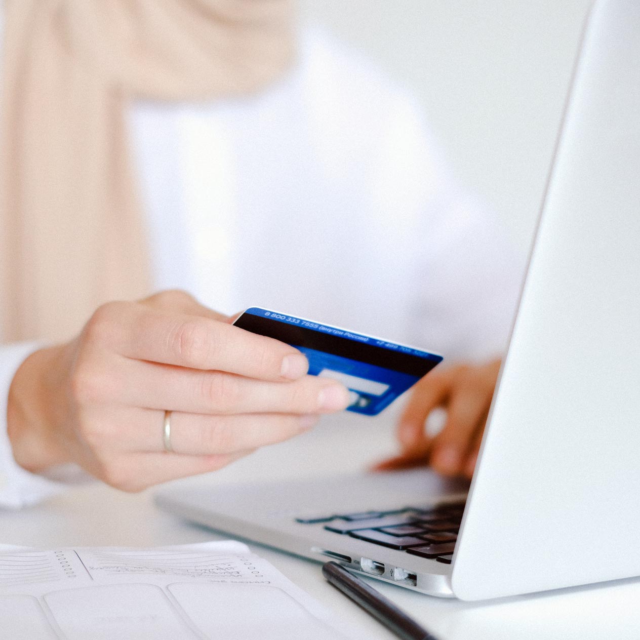 Woman using laptop and holding credit card